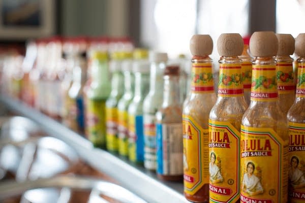 A counter lined with different hot sauces at Sea Salt Eatery.