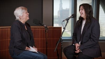 Two women have a conversation in a recording studio