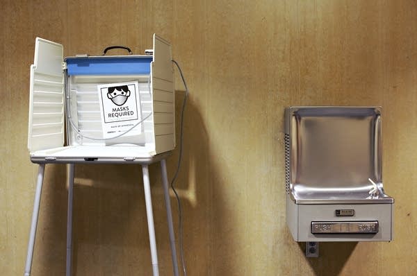 A voting booth with a sign 