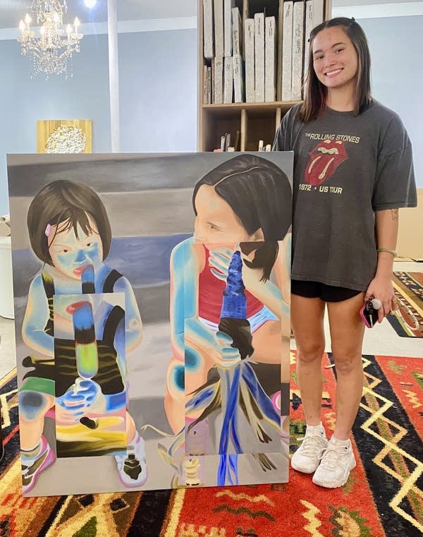 A person stands with their art