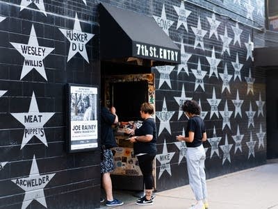 Fans wait outside a music venue with stars on its walls