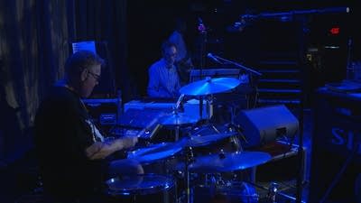 Three musicians performing together onstage