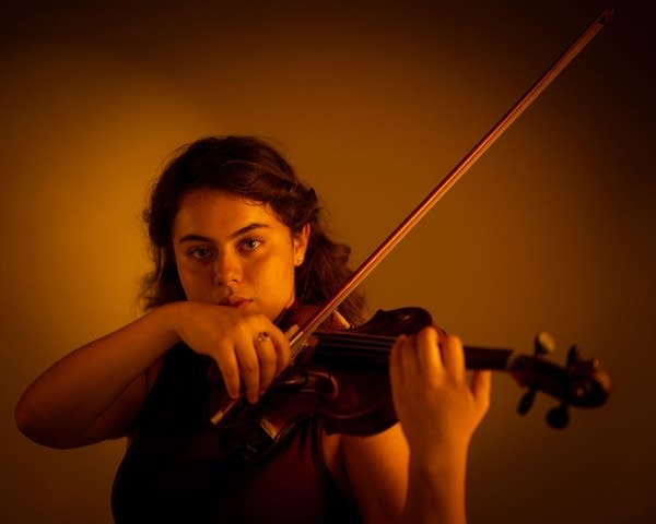 A woman plays violin for a studio portrait