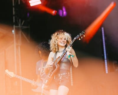 Two musicians performing together on a large outdoor stage