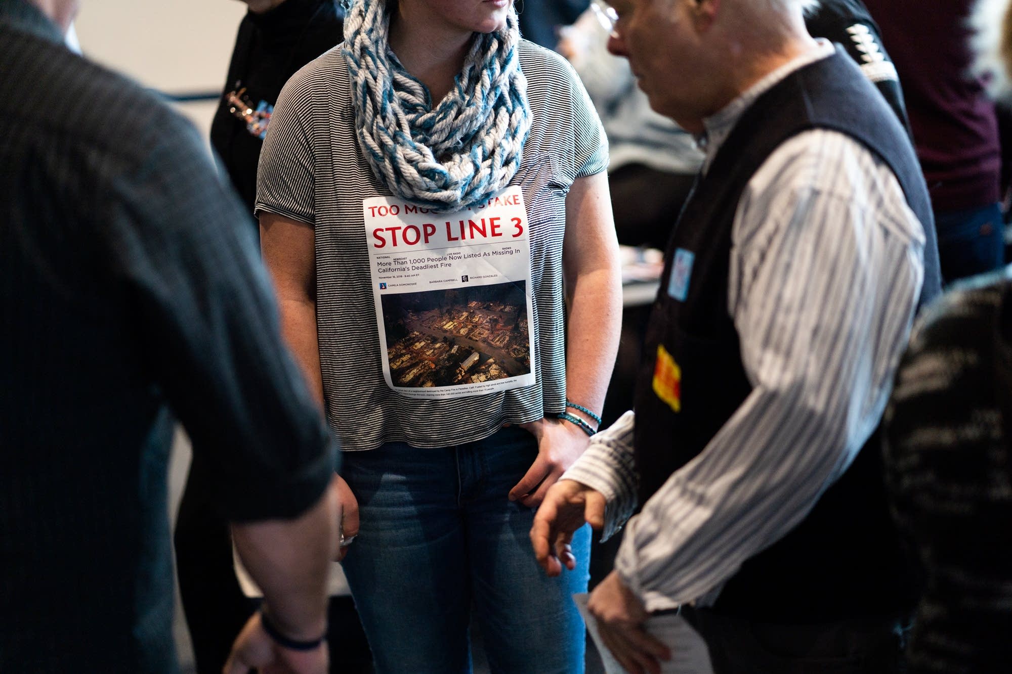 Enbridge Line 3 Oil Pipeline opponents wear printed news articles.