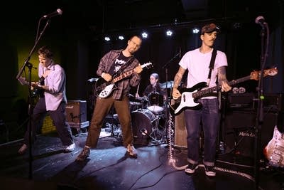 A four-piece band performing onstage in a music venue