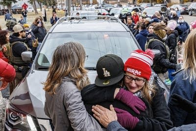 People gather and embrace during a police action.