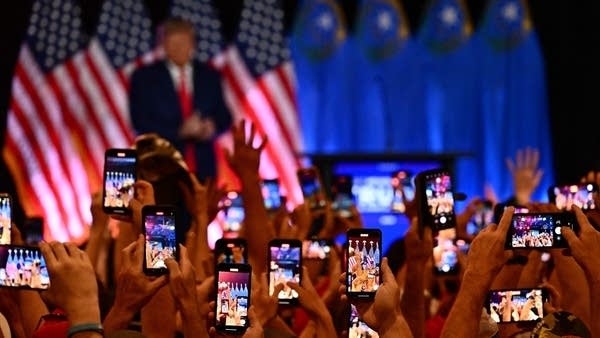 People photograph former President Donald Trump at a rally in July. 