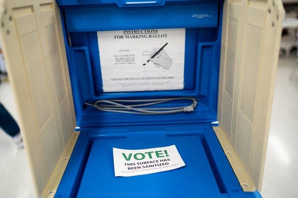 A card that says "VOTE!" in a blue booth.