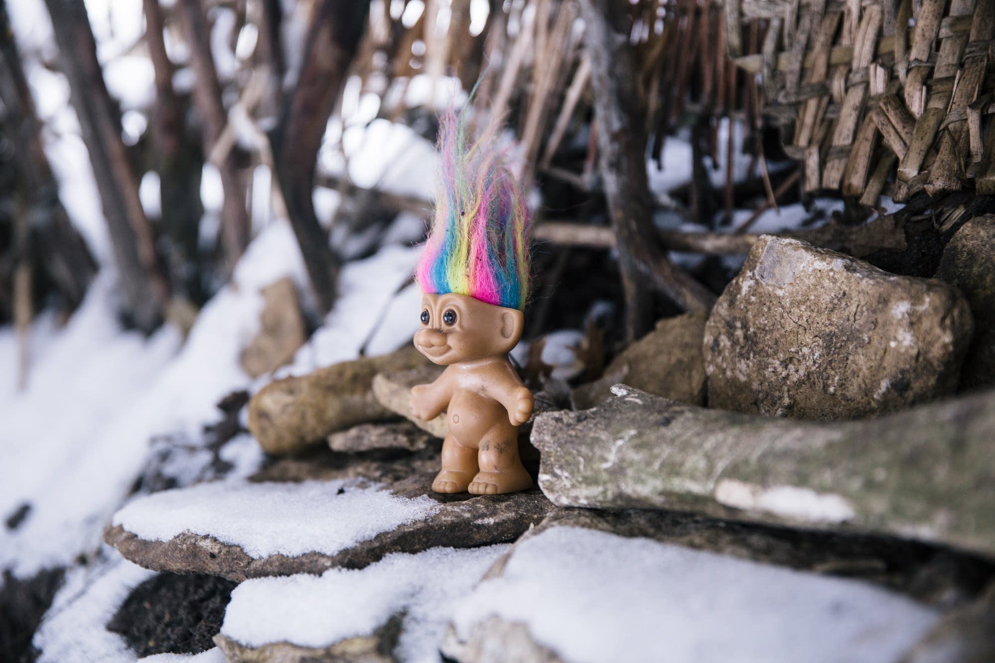 A troll doll stands in one of the stick forts.
