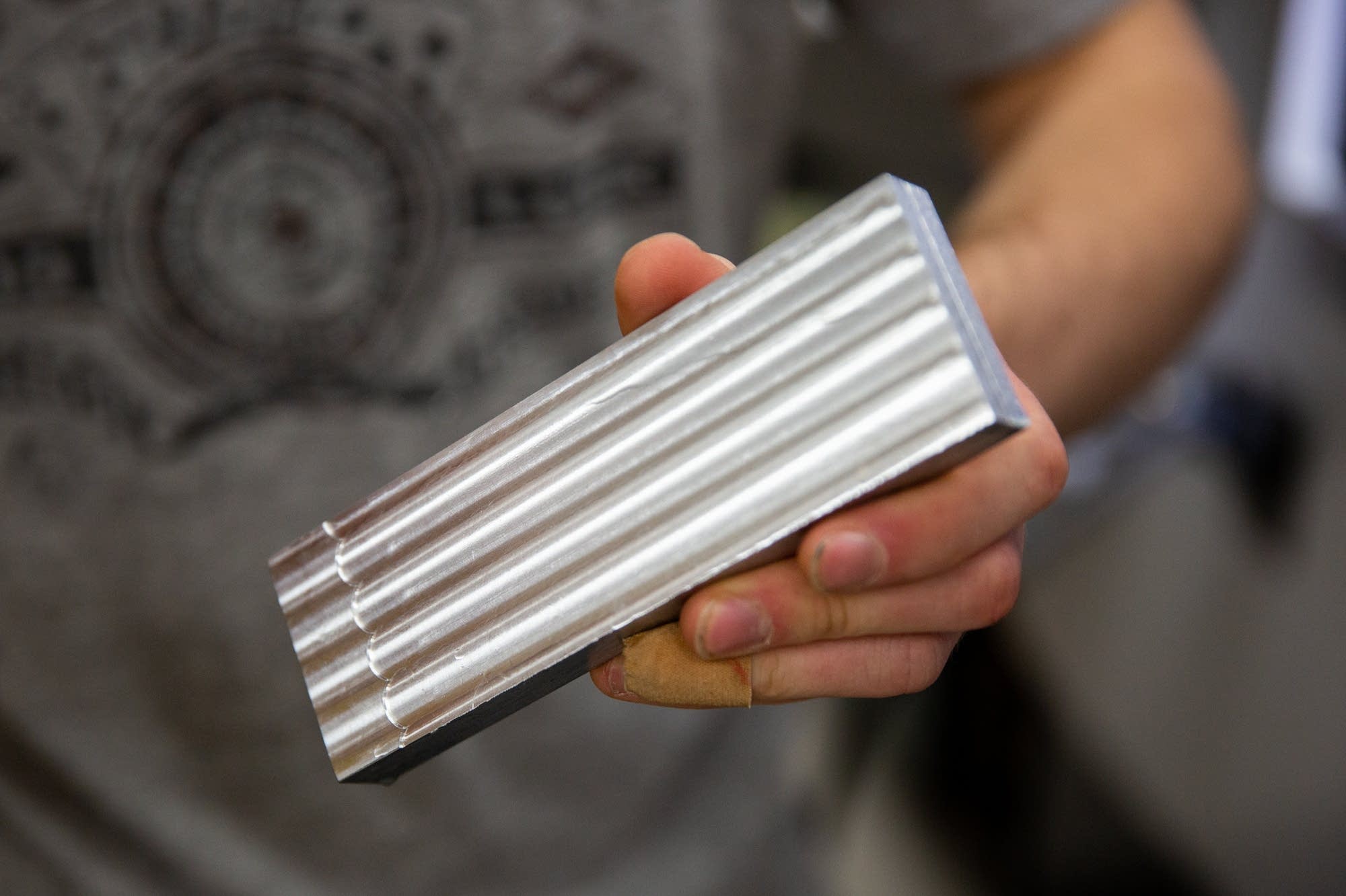 Andre Keller holds a block of metal he's started shaping.