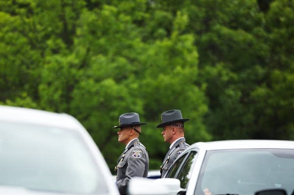 Law enforcement officers walk through the parking lot.