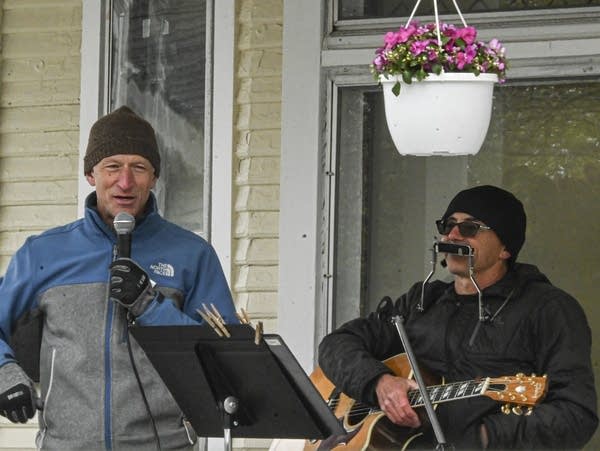 Two men on the front porch of a house.