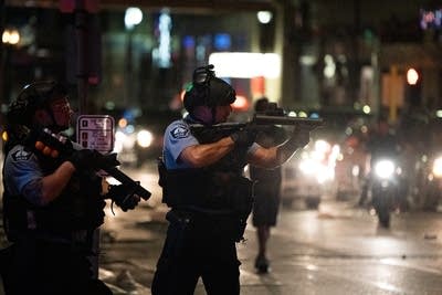 A police officer points a gun.