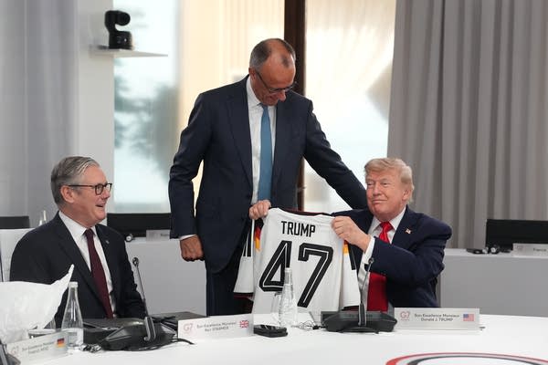A man presents President Trump with a jersey.