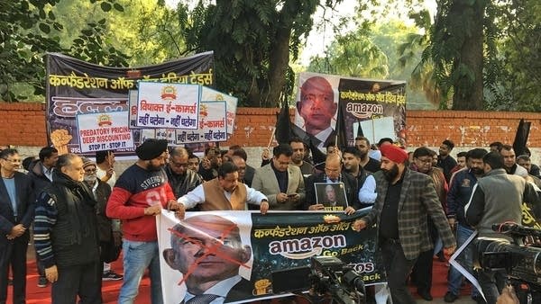 Protesters gather outside an event hosted by Amazon boss Jeff Bezos in New Delhi.