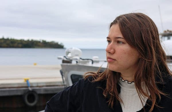 A woman looks out on the water on a cloudy day.