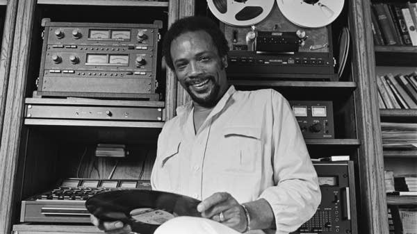 Poster Black-and-white photo of a man in front of recording equipment in a studio