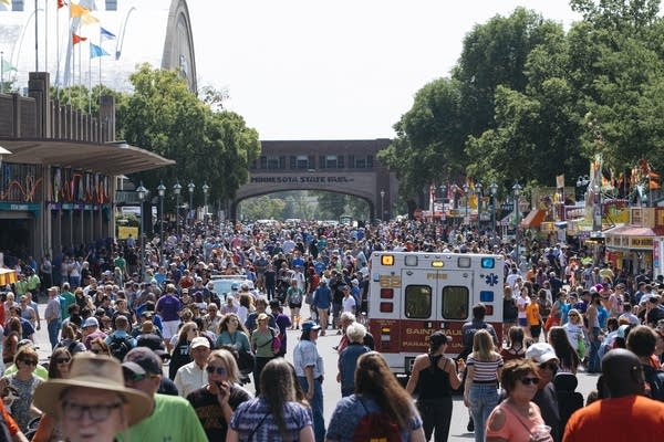 An ambulance cuts through a thick afternoon crowd on Thursday.