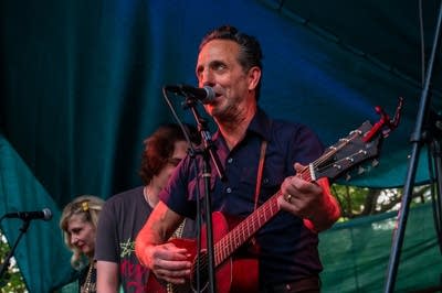 A rock band performing on an outdoor stage