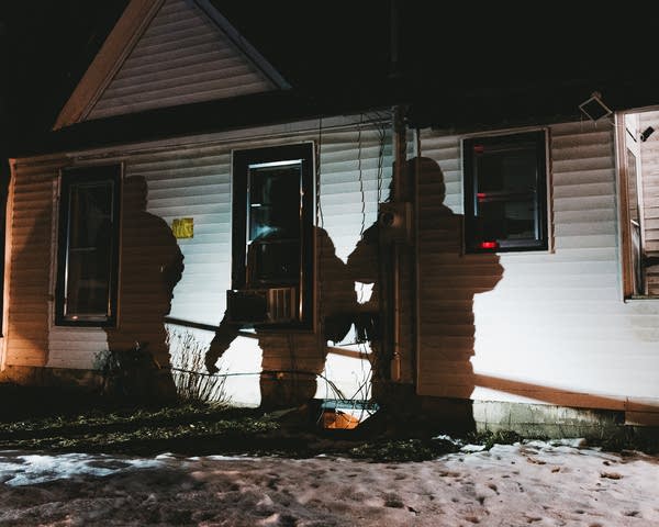 A shadow of ICE agents on a home