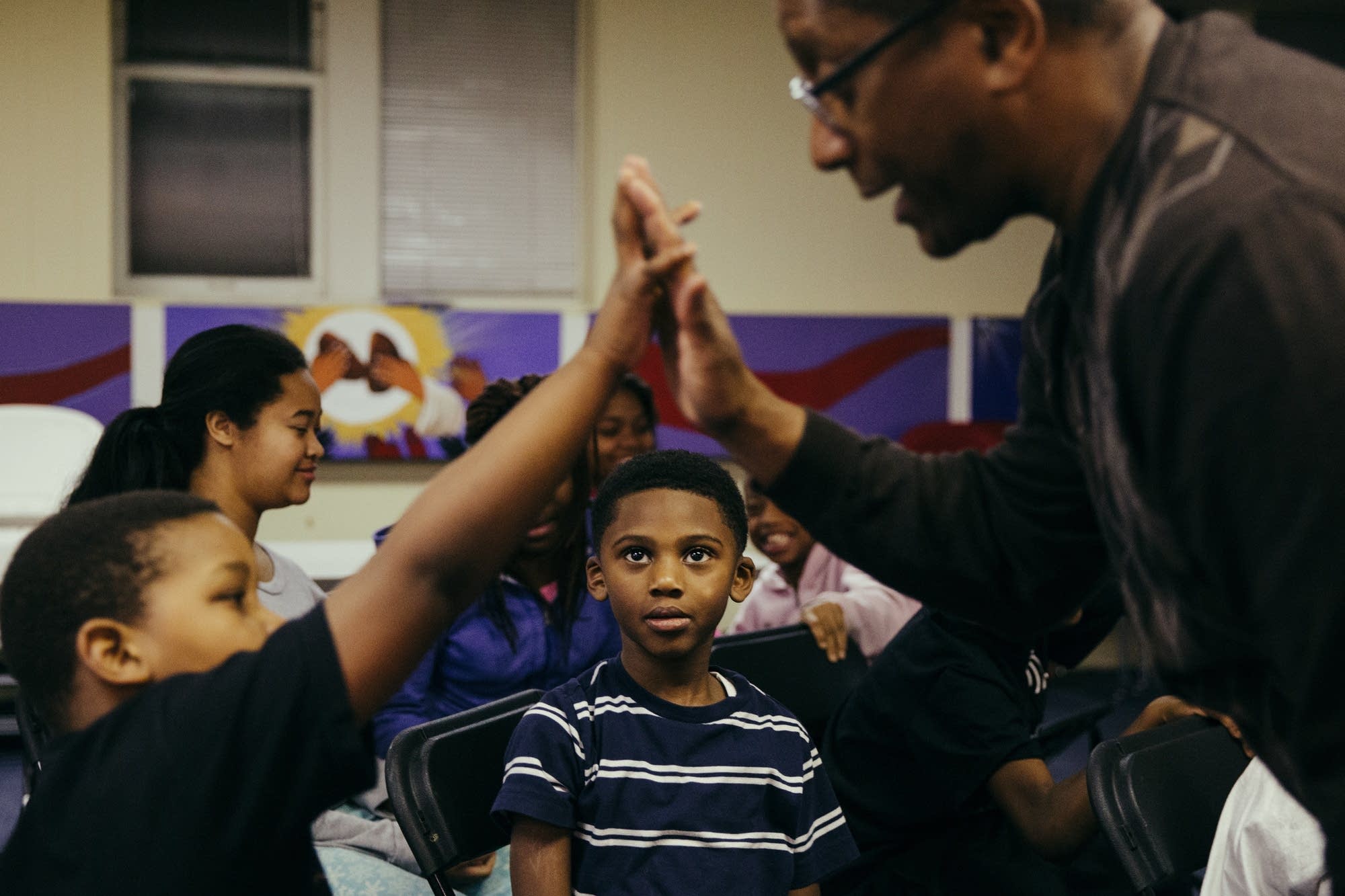 Six-year-old De'Veon watches a high-five.