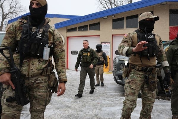 Agents stand around in a gas station.