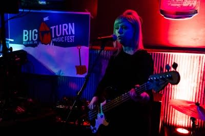 A musician sings and plays bass in a bar
