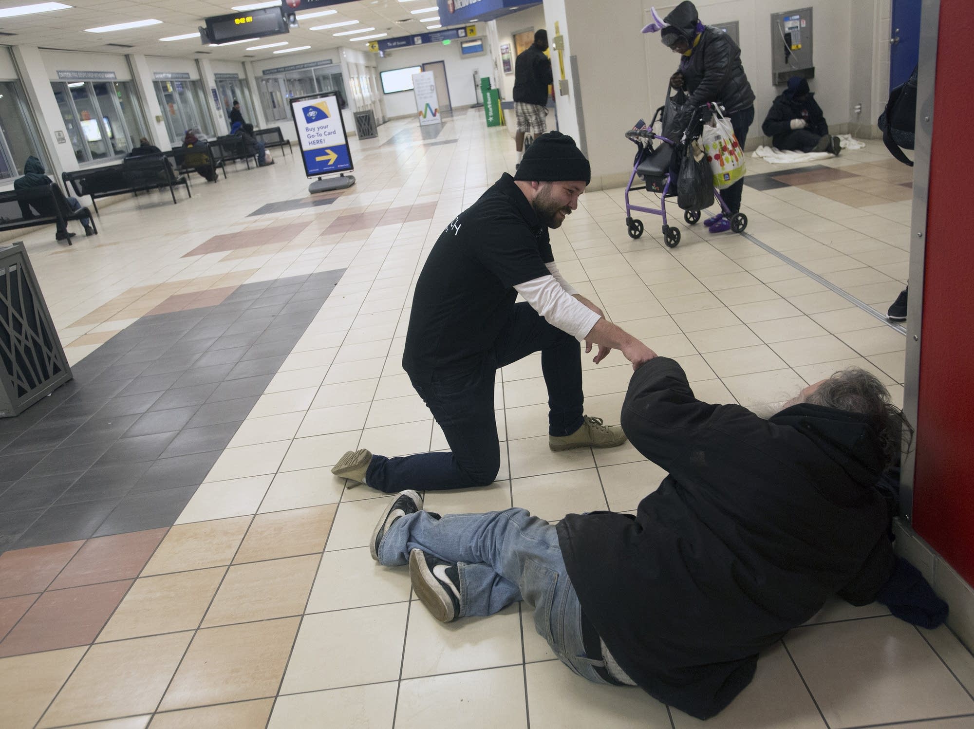 Chris Knutson of St. Stephens talks with a homeless man at the LRT.