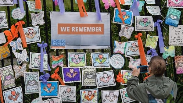 A person takes a picture at the "Naming the Lost Memorials" installation to remember the lives lost due to the coronavirus pandemic at The Green-Wood Cemetery on June 11, 2021 in New York City. - An estimated 600,000 Americans have died from Covid-19. The memorial consist of tens of thousands of nameplates with personalized drawings and photos, created by the families and friends of those who have lost loved ones to the virus.