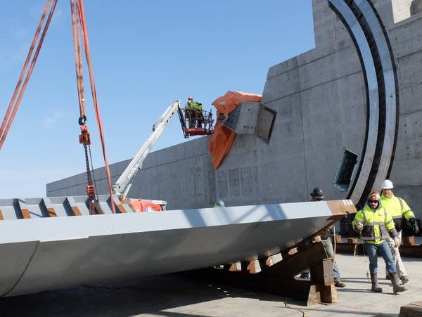 construction workers next to a large concrete structure