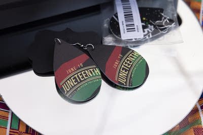 Red, green and black earrings with "Juneteenth" written in gold on them.