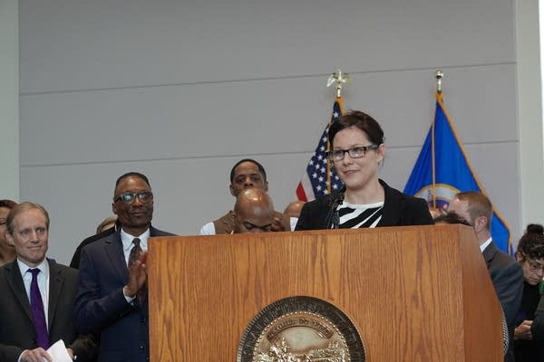 Woman stands at podium