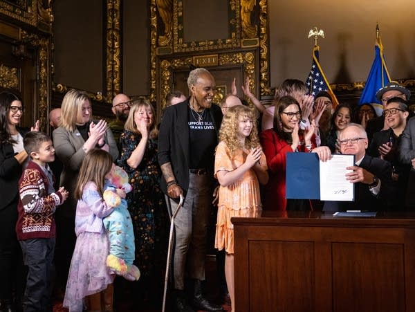 People cheer after the governor signs a bill