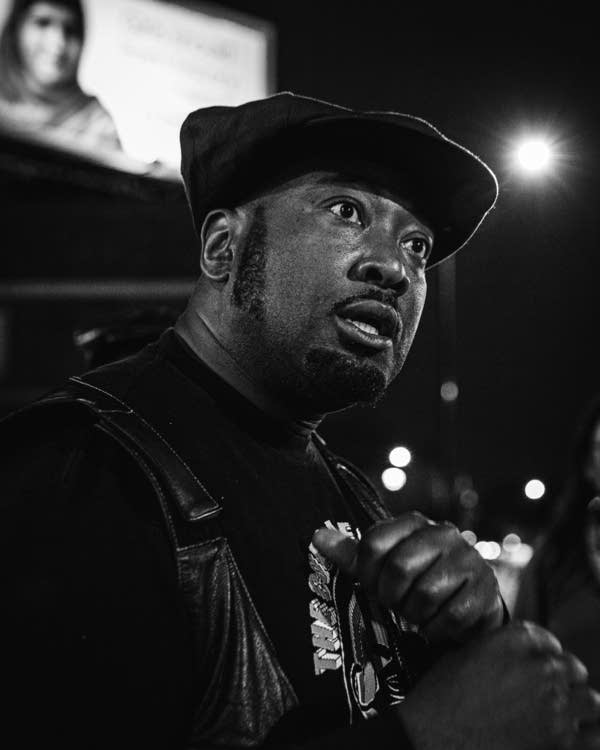 A Black man stands in a street