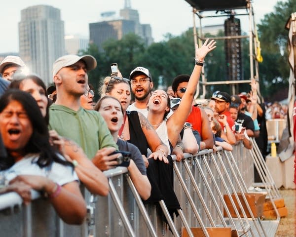 Music fans singing at a concert at an outdoor festival