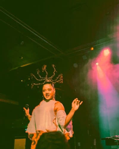 XINA sings into a microphone onstage at Fine Line.