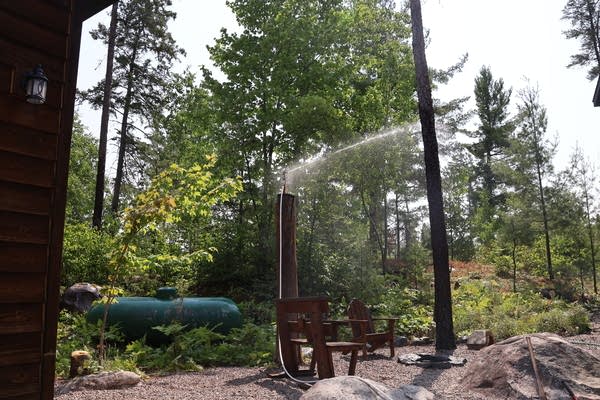 A sprinkler running next to a house
