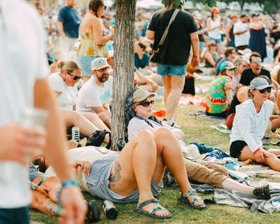 Music fans relax on the lawn at a summer music festival