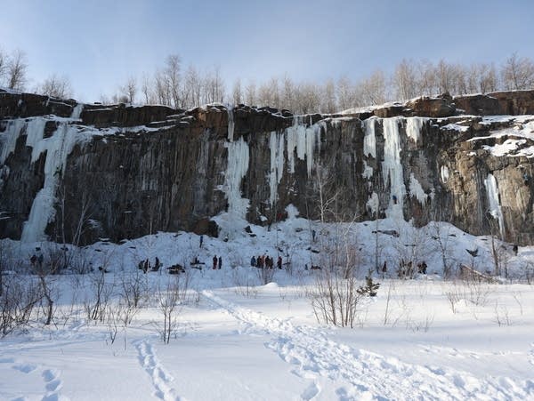 People line the bottom of an icy quarry