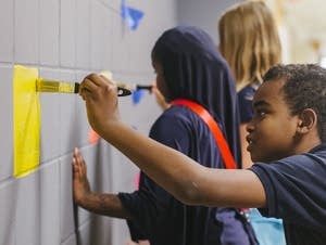Fourth-grader Jeffrey Willis paints on the mural.