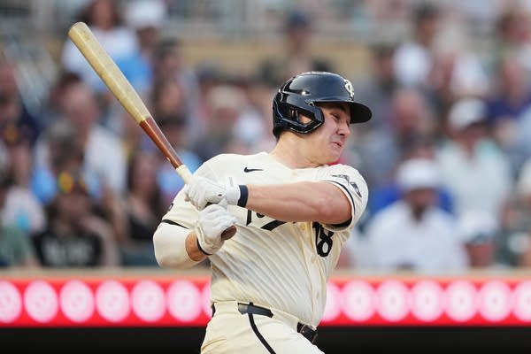 A Twins batter follows through after a swing.