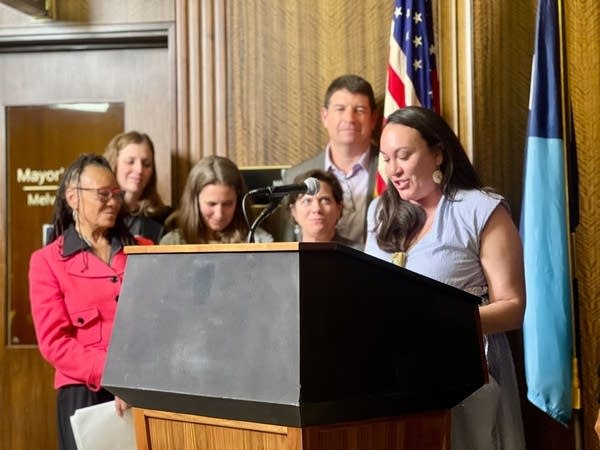 A group stands behind a podium during a press conference.