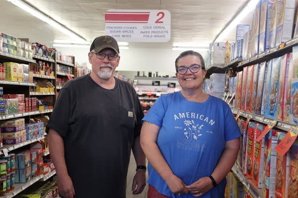 Two people posing for photo in a grocery store