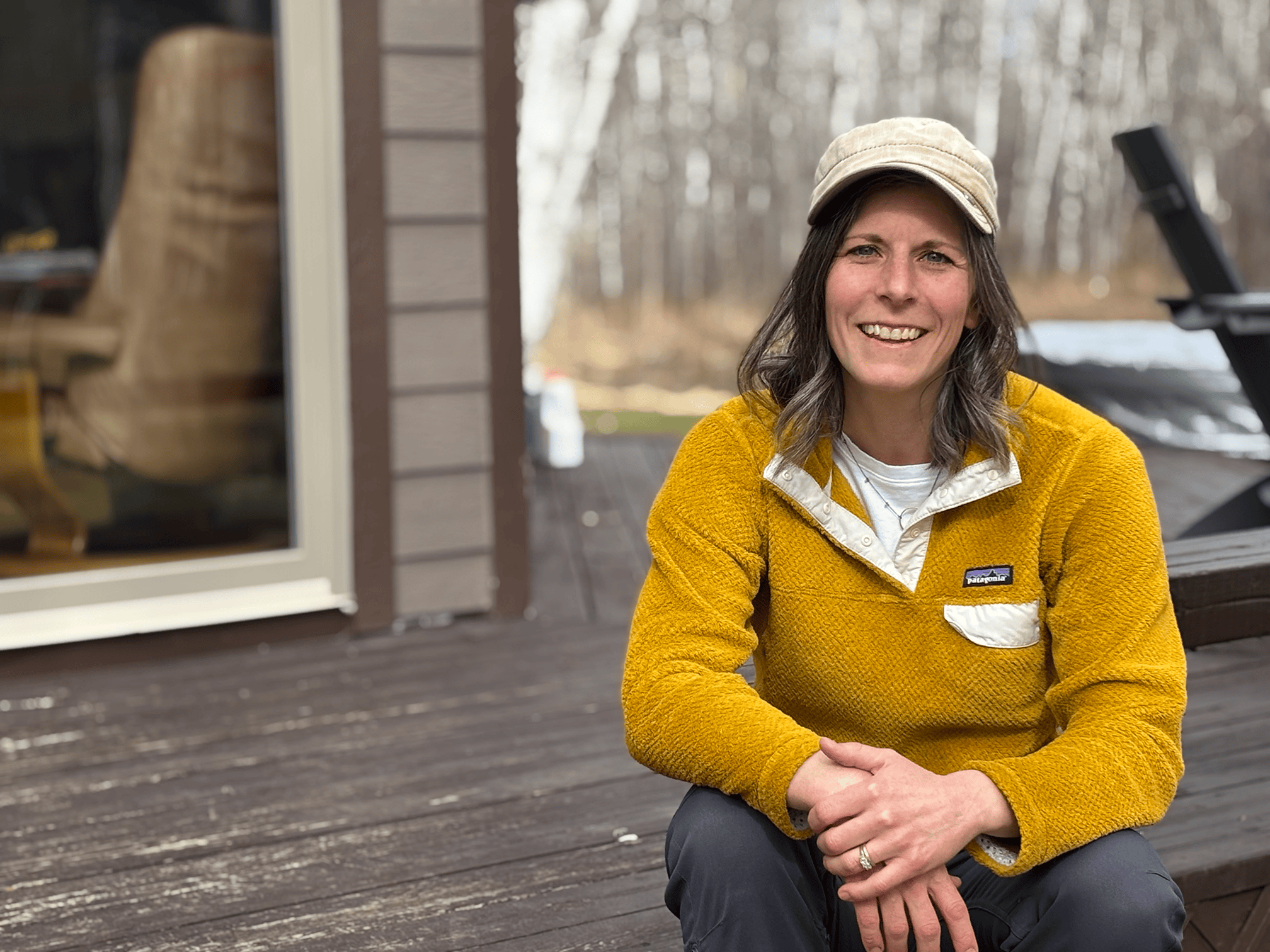 A portrait of a woman in yellow sitting on a porch step.