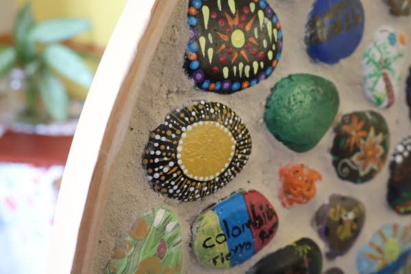 Close-up of stones embedded in a mosaic, all decorated with bright, multicolor paint.