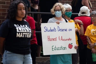 A person holds a sign. 