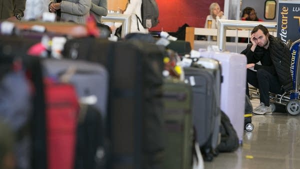 After being stranded in Atlanta during a layover, Penn Ryan of Madison, WI waits to find his luggage near rows of unclaimed baggage at Hartsfield-Jackson Atlanta International Airport on December 18, 2017 in Atlanta, Georgia.