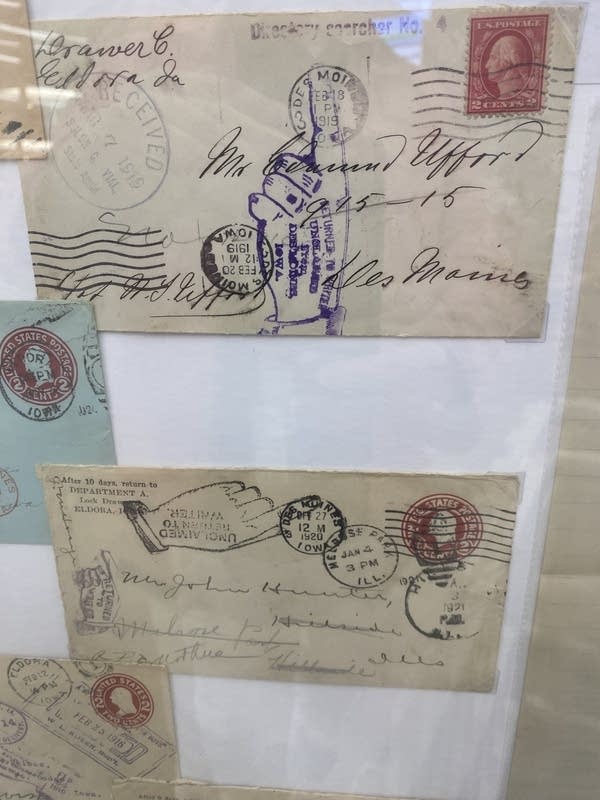 Two vintage envelopes on display, covered in postage stamps.