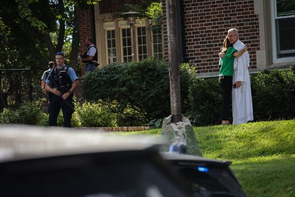 Two people embrace outside a school